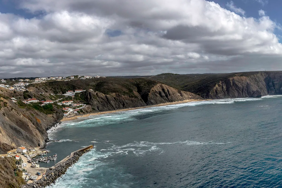 The cliffs and bay at Praia da Arrifana with the Pedra da Agulha