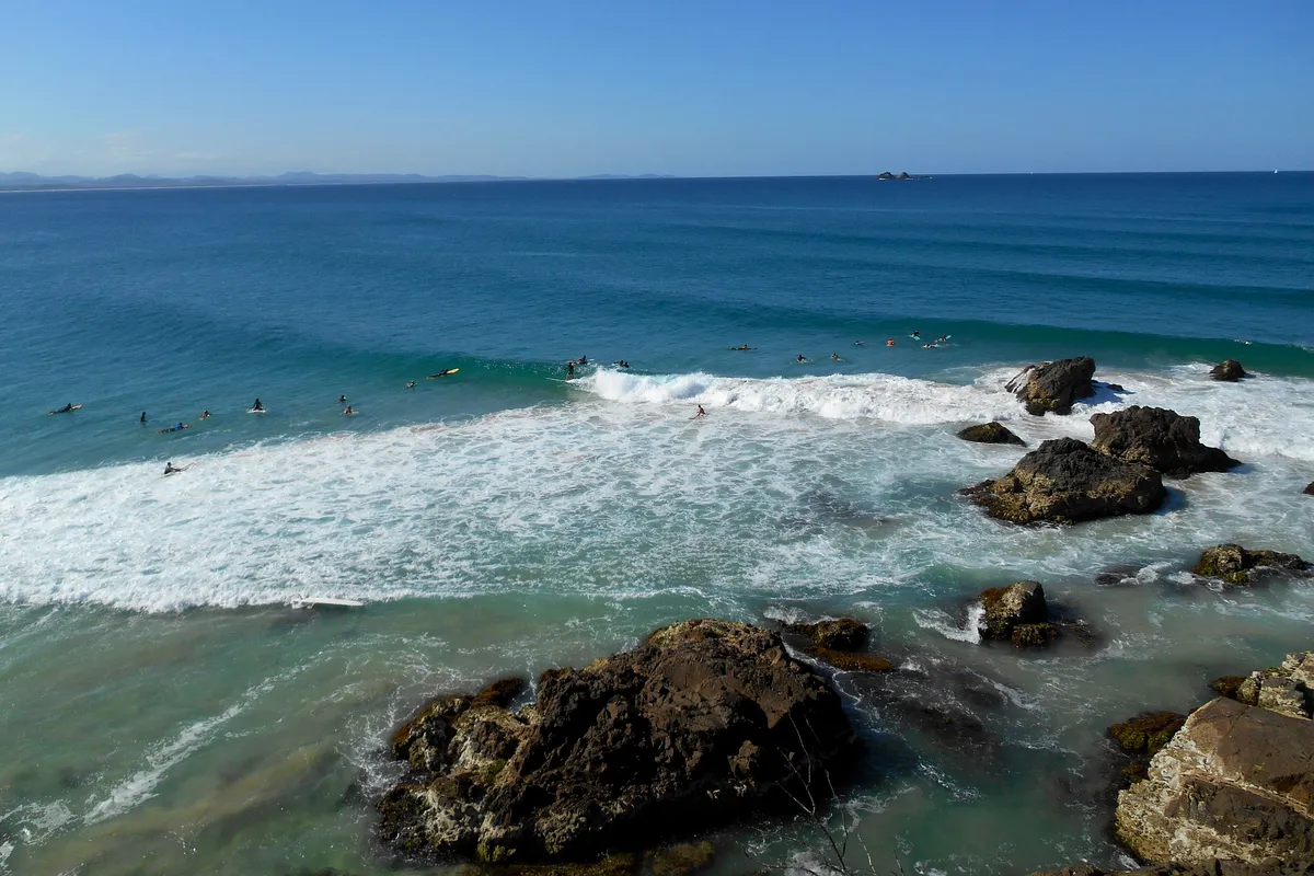Surfers among the rocks of the Cape Byron marine protected area