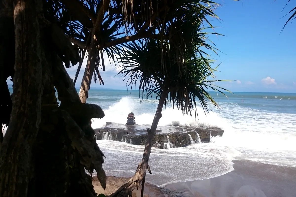 Waves washing around the temple rock at Batu Bolong, Canggu