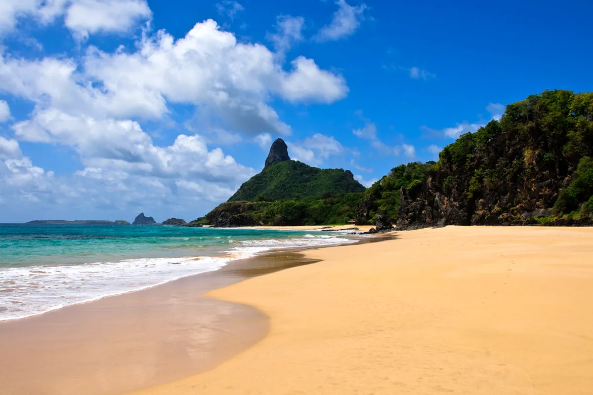 Morro do Pico rising above the beach and turquoise sea at Fernando de Noronha, Brazil