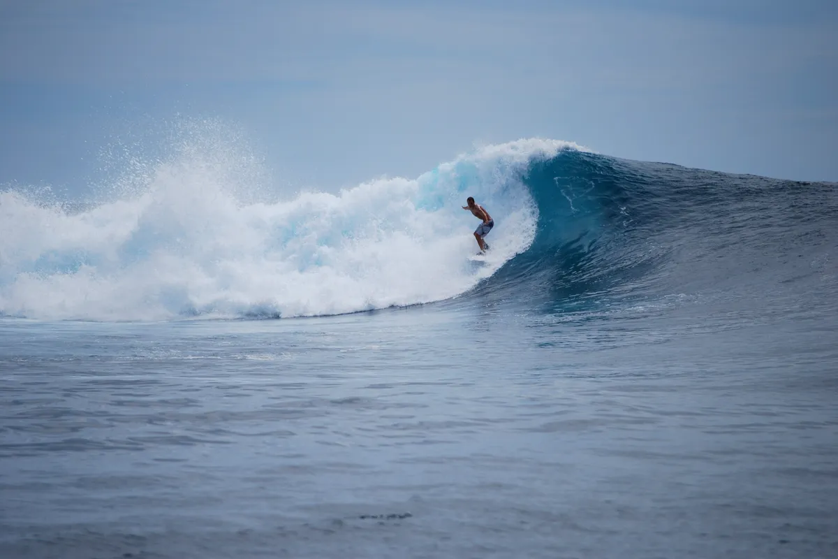 A surfer riding a barrel in the Mentawai Islands