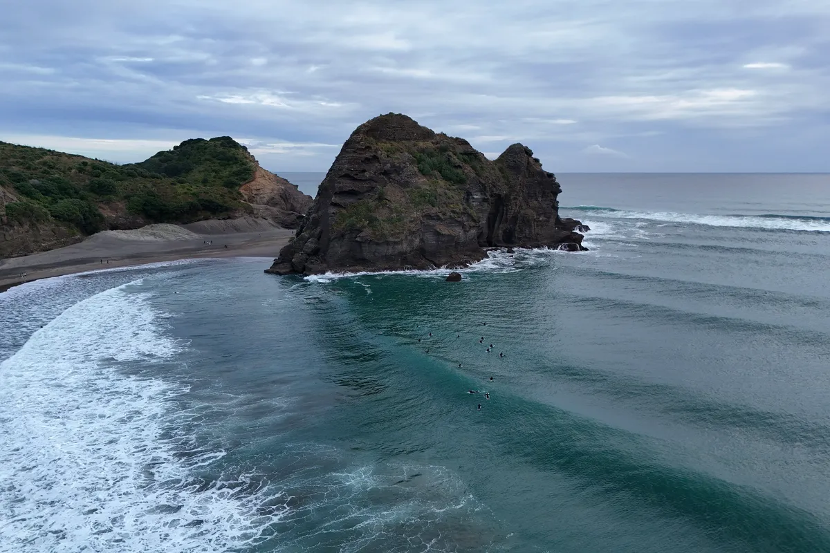 Lion Rock and the black-sand surf beach at Piha, New Zealand