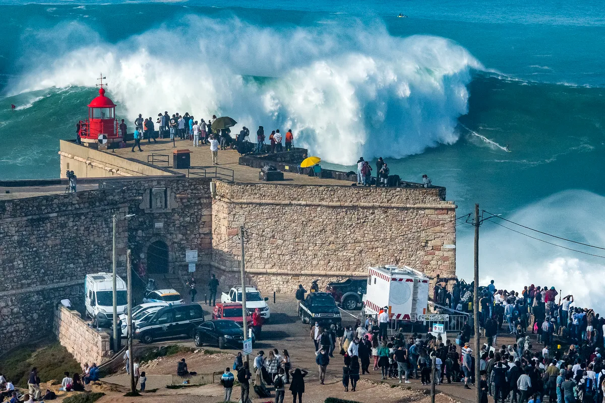 Crowds at Nazaré fort watching giant waves at Praia do Norte