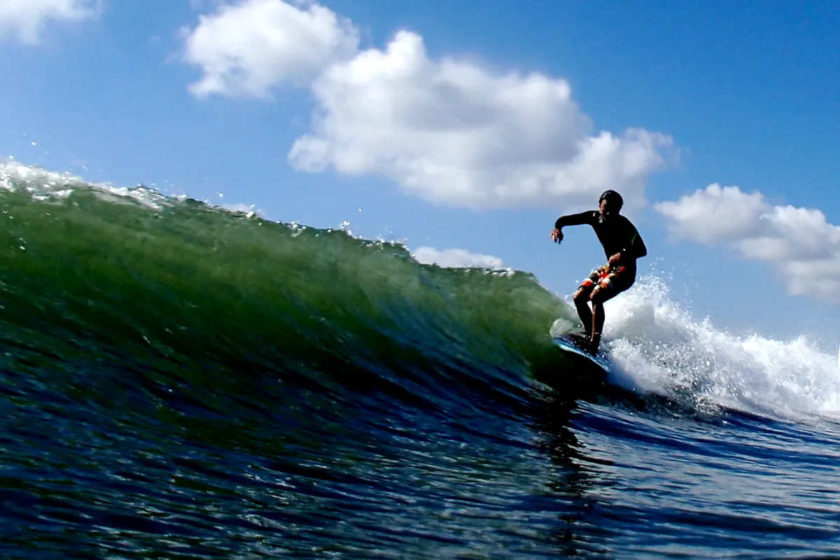 A surfer riding a green wave on the Kujukuri coast of Chiba
