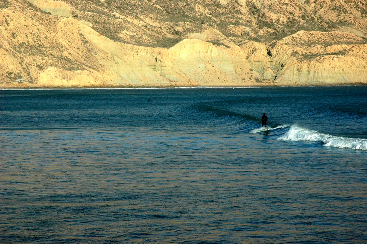 A long wave peeling through the bay at Imsouane below the desert hills