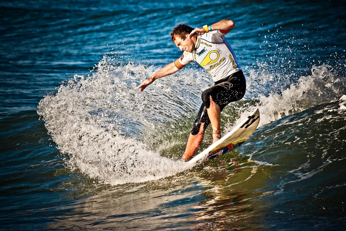 A surfer carving through spray during the Lacanau Pro