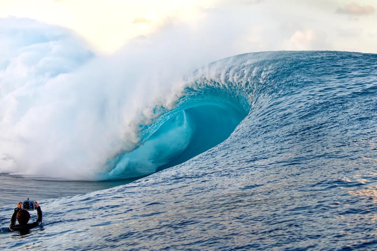A surfer in front of a heavy, hollow wave at Teahupoo, Tahiti